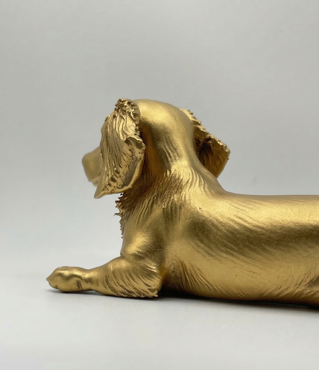 Gold-colored dog figurine on a white background