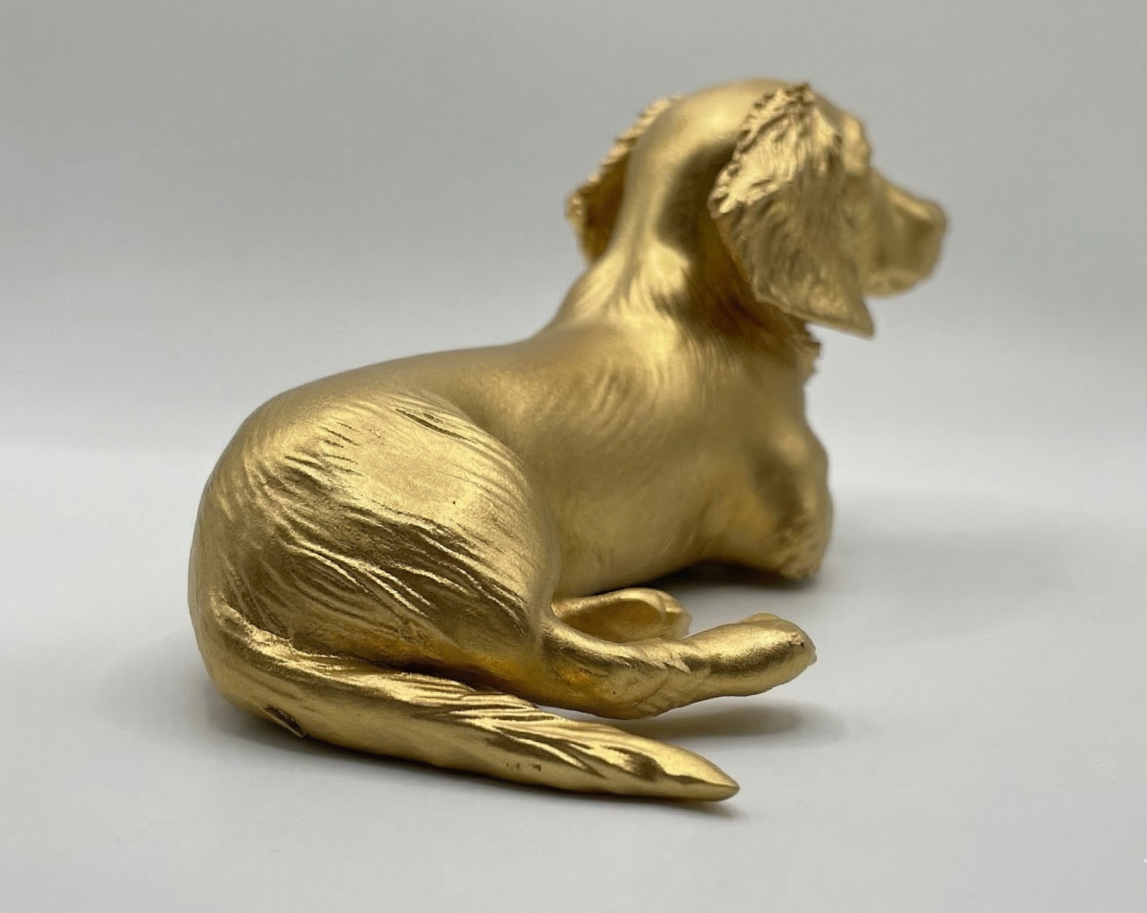 Gold dog figurine on a light gray background